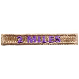 The words 2 Miles are stitched in purple thread on a brown rectangle.
