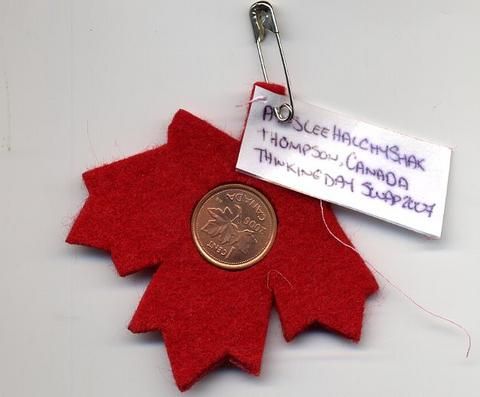 A maple leaf DIY craft with a penny in the middle.
