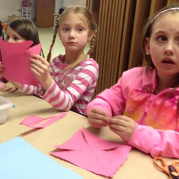Three girls making paper crafts.