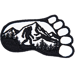 A foot print with a bigfoot and mountains inside.