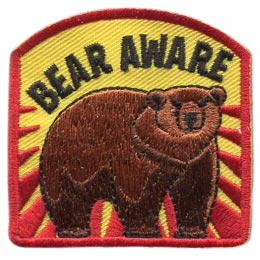 A bear stands threateningly under the words Bear Aware.