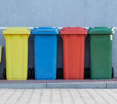 Yellow, blue, red and green trashcans.