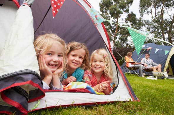 Three girls playing in a tent.
